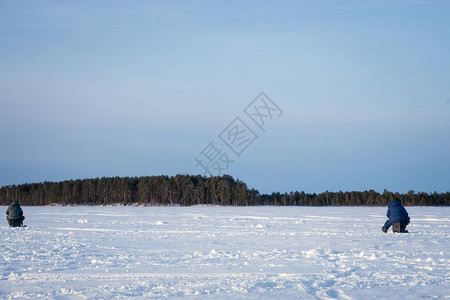 冬天季捕冬钓鱼两个渔民在森林背景下背景图片