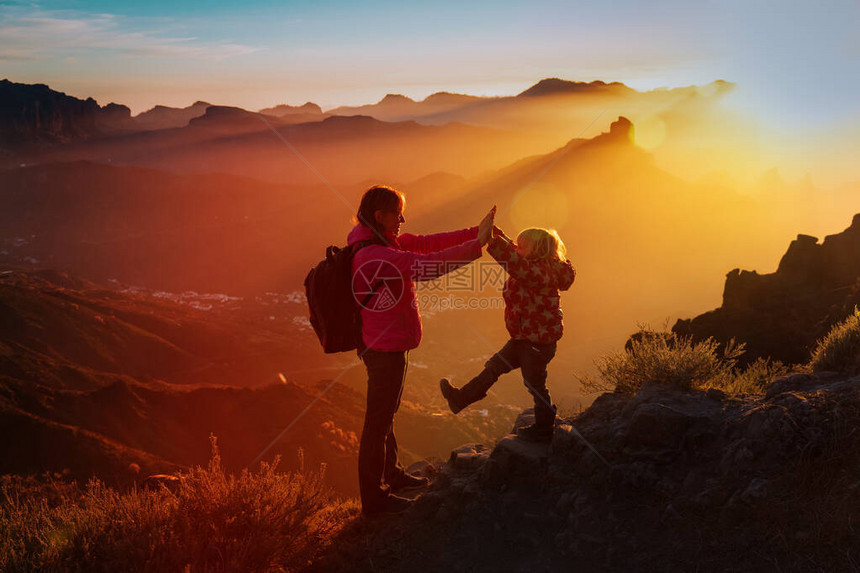 母亲和小女儿在日落山上享受旅行图片