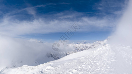 在山顶上开始下雪的暴风雪阳光明媚的一天图片