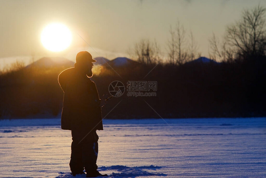 一只渔民在日落时冬图片