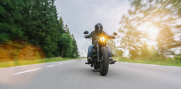 骑在林道上的摩托车菜刀在摩托车之旅中驾驶空荡的道路玩得开心个人文图片