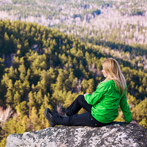 坐在悬崖边缘的年轻女子山顶图片