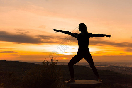 日落时女教练瑜伽练习瑜伽概念勇士姿势维图片