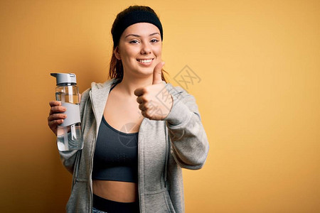 年轻漂亮的女运动员穿着运动服喝水的瓶做运动图片
