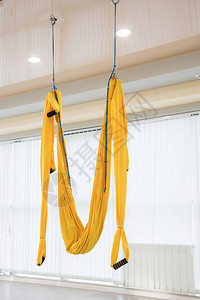 黄色苍蝇瑜伽吊床挂在体育馆图片