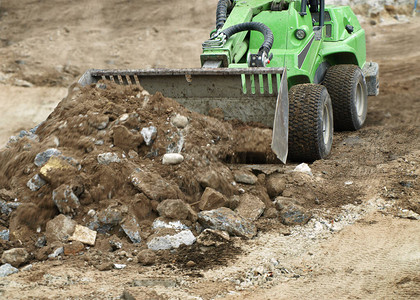建筑轮式搬运车在施工地进行挖掘工作图片
