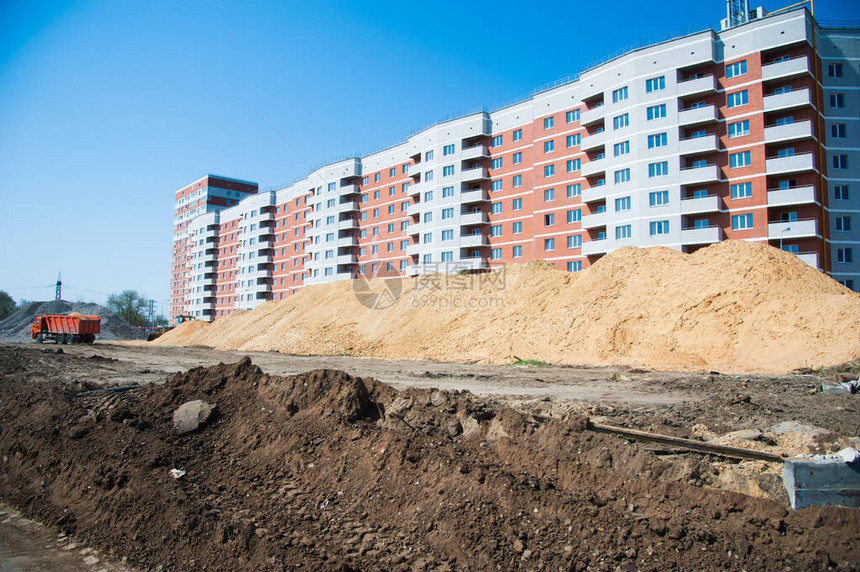 修复旧的和建设新的柏油路在新的道路施工现场工作的挖掘机平图片