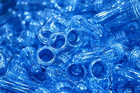 注射过程的预形堆积集装箱中的PET瓶子工厂内的塑料饮用水瓶制造过程背景图片