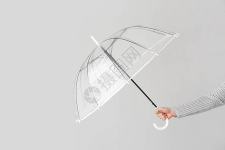 浅色背景下带时尚雨伞的女手背景图片