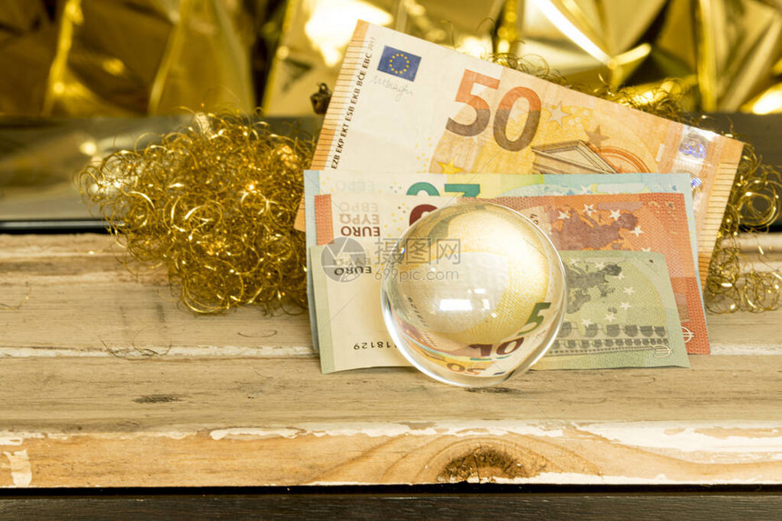 带欧元钞票和圆纸的玻璃球用温图片