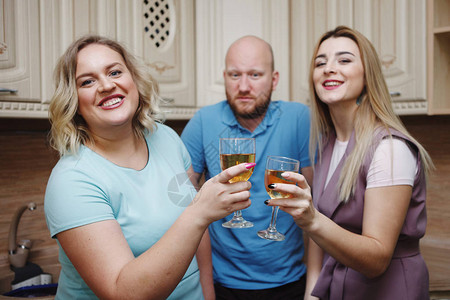 一个年轻漂亮肥胖的金发女郎和她的朋友正在用酒杯喝酒图片