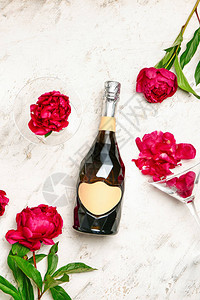 浅色背景中的一瓶香槟和鲜花图片