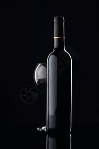 酒瓶和一杯红酒在黑图片