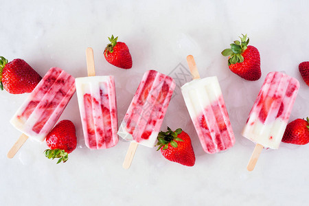 一组草莓香草酸奶冰块在白色大理石背景的图片