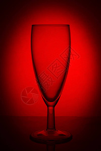 红色背景的红色月光上的空玻璃香槟图片