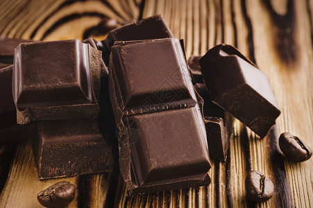 苦巧克力黑巧克力堆肥立方块和木制背景的图片