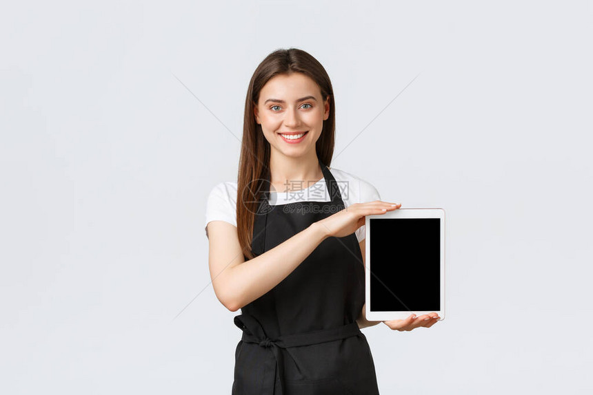 杂货店员工小企业和咖啡店概念穿着黑色围裙的可爱商店女售货员微笑着展示数字平板电脑屏幕咖啡馆工作人员图片