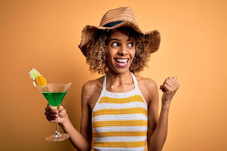 穿着暑假帽子喝鸡尾酒手拿着拇指露面笑着脸的非洲美籍旅游女观光图片