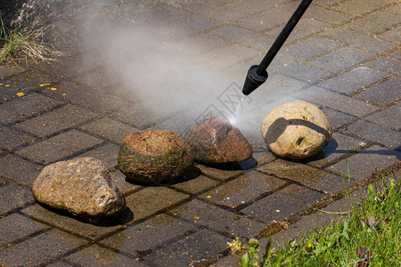 高压清洗机的喷雾器清洁乡间别墅花园线上的石头图片