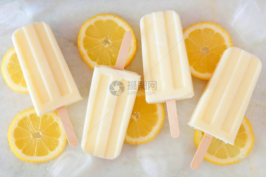 健康柠檬酸奶冰棒新鲜柠檬片散落在白图片