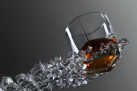玻璃桌上有冰的威士忌杯图片