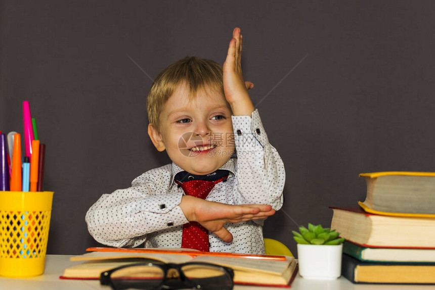 男孩伸出手一个学龄前儿童坐在书桌前图片