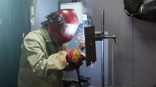 面罩中的焊工金属产品由焊机接背景图片