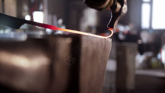 铁匠用锤子在螺旋中用锤子把较长的金图片