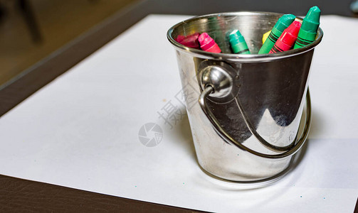 铝桶闭合式水桶中的蜡笔背景图片
