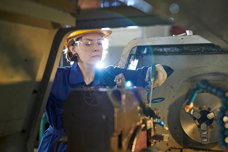妇女工人在金属生产厂复制空间操作机器组的肖像图片