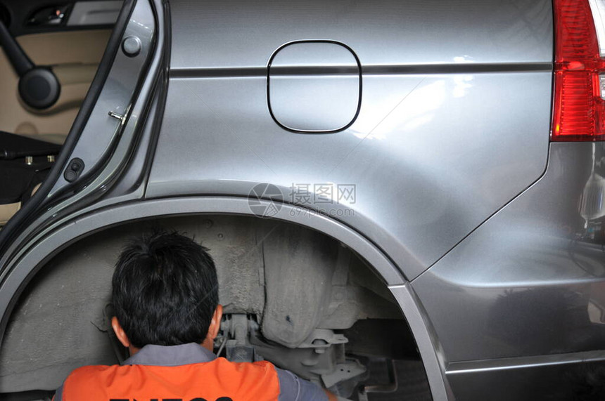 新轮胎更换过程中的汽车修理工车库中的汽车制动器维修带拆卸车轮的汽车上的制动器车库的汽车制动部件无车轮图片