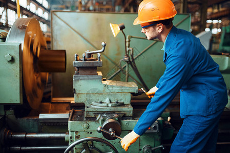 穿制服和头盔的工人在车床工厂作工业生产金属工程图片