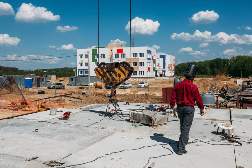 在一个建筑工地用一个建筑起重机的黄色钩子在红色图片