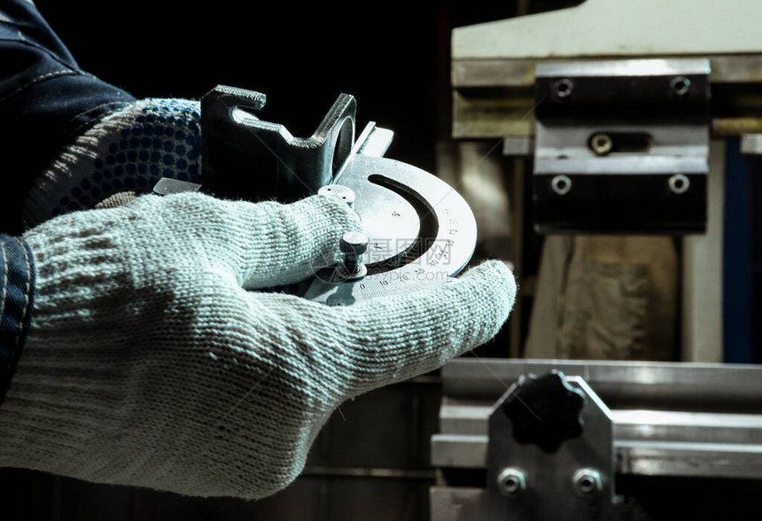 工人在工厂用带有测角仪的测量工具测量零件一名工人在工厂图片