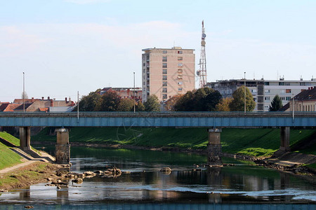 低水位当地河流上的浅蓝色旧金属桥景观背景图片