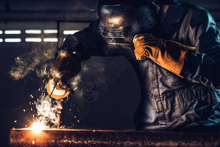 金属焊工使用电弧焊机在工厂焊接钢图片