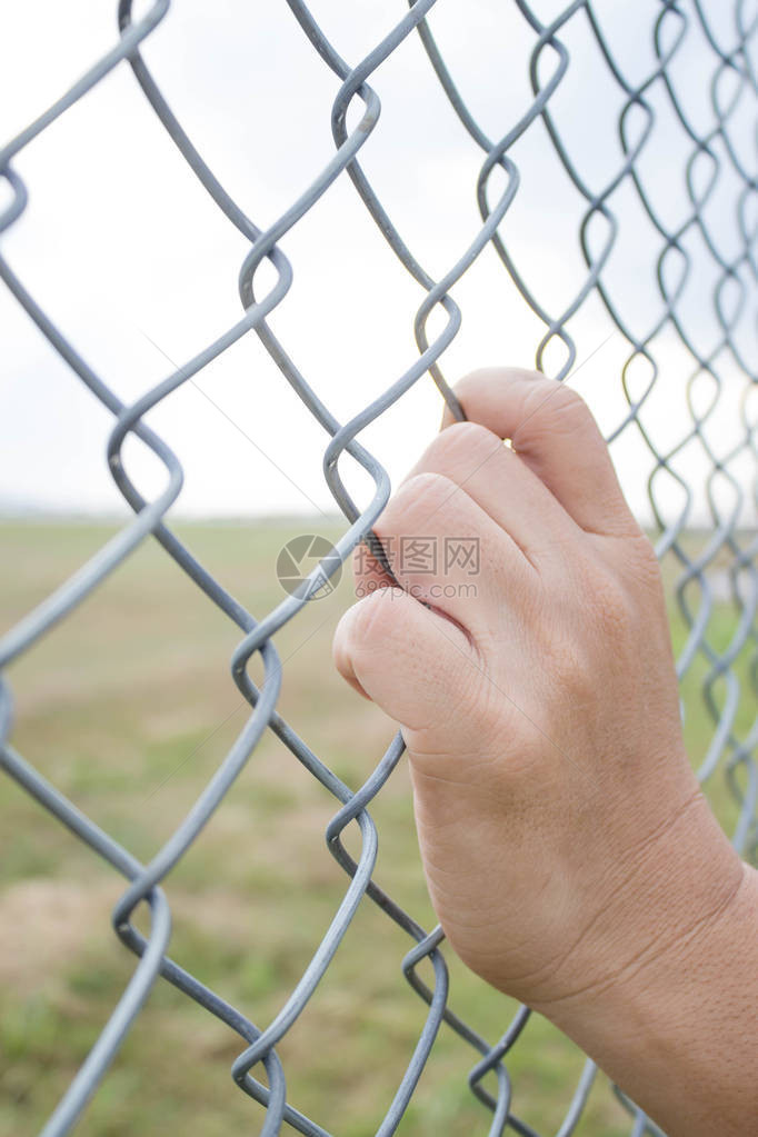 在机场的铁链栅栏上男子手握着铁链为有图片