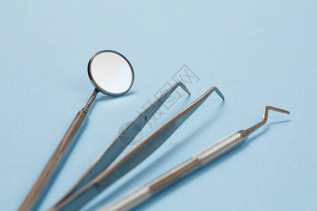 一套用于牙科治疗的金属牙科器械蓝色背景上的医疗工具专注于图片