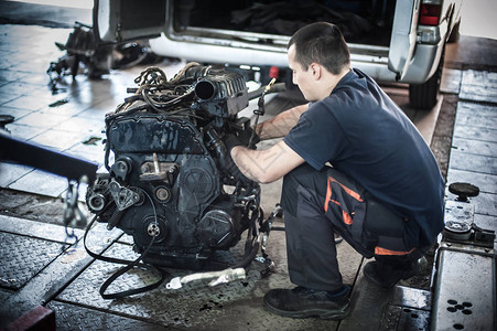 从汽车上拆下发动机汽车主汽车修理工在服务车间检查和修图片
