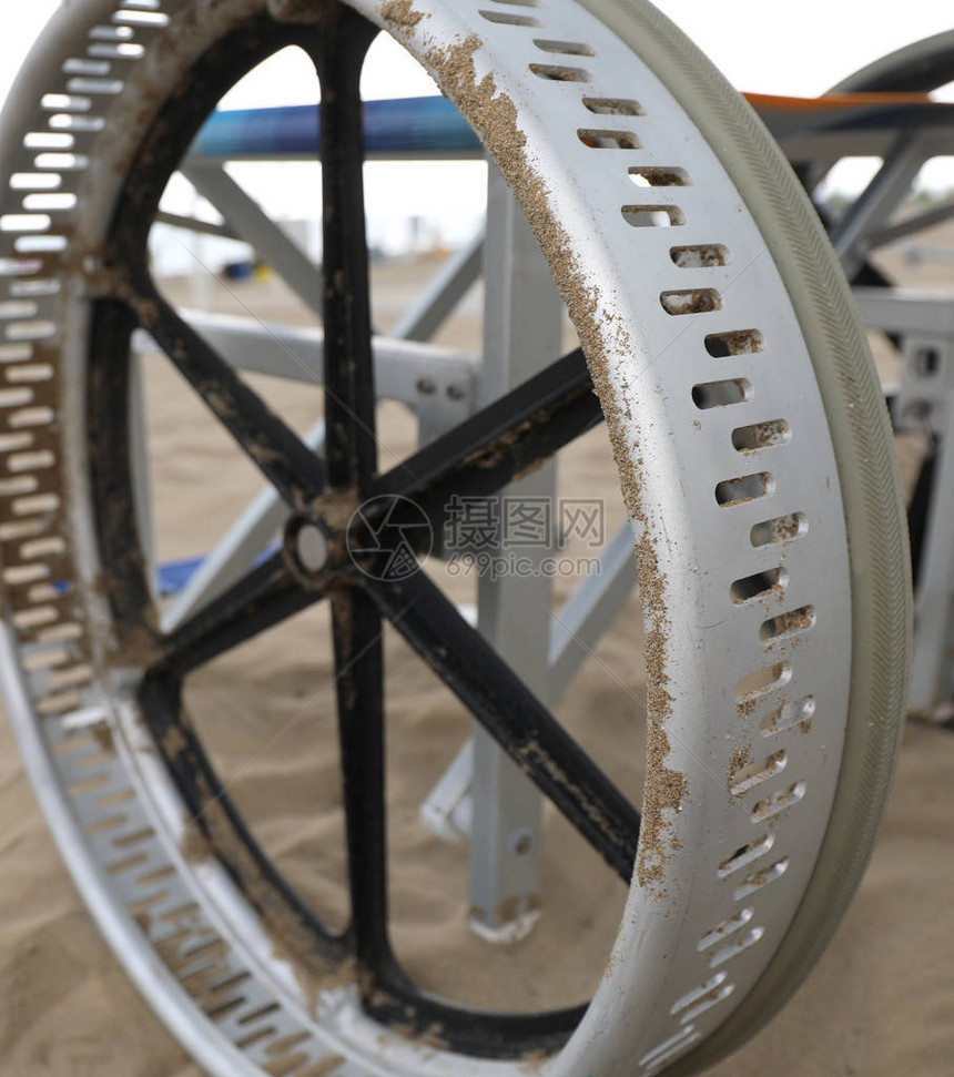 特别轮椅的巨型特殊车轮在海滩沙上轻而易图片