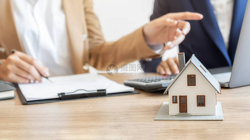 房屋模型与代理和客户讨论购买获得保险或贷款房地产图片
