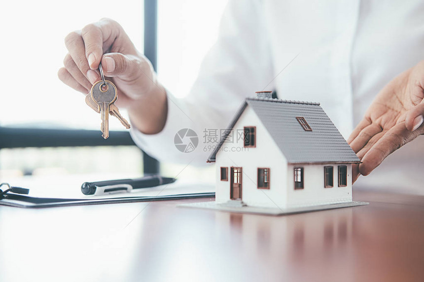 房屋模型与房地产经纪人和客户讨论购买房屋保险或贷款房地图片