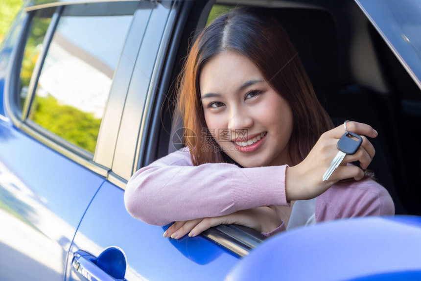 亚洲女司机笑着展示新车钥匙坐在车里图片