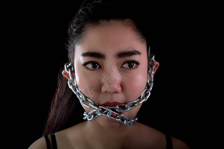 身穿肖像的亚洲年轻女被铁链锁在嘴里图片