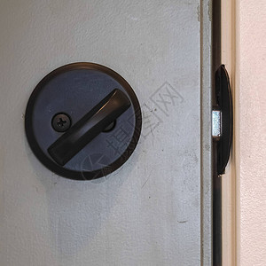 方形框架关闭黑色门把手和锁定的闩锁现代房屋中黑色门把手图片