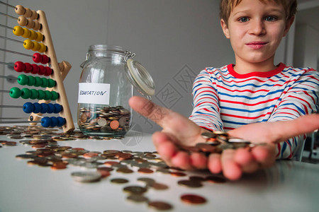 儿童把硬币放进罐子里孩子在数钱图片
