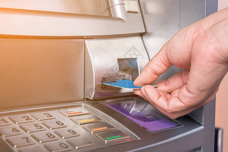将自动取款机卡插入银行机器背景图片