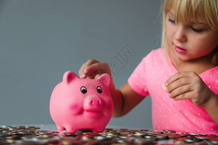 儿童储蓄钱可爱女孩把硬币放进小猪银行图片