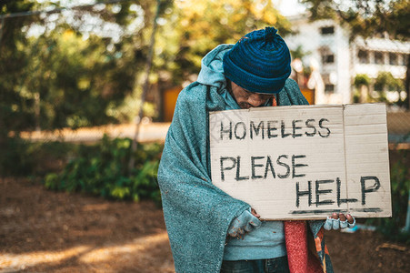 乞丐们站在街上写着无家可归的信图片