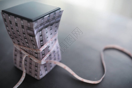 房贷债务房子将用一个美元符号的测量磁带来拉动在房屋中背景图片